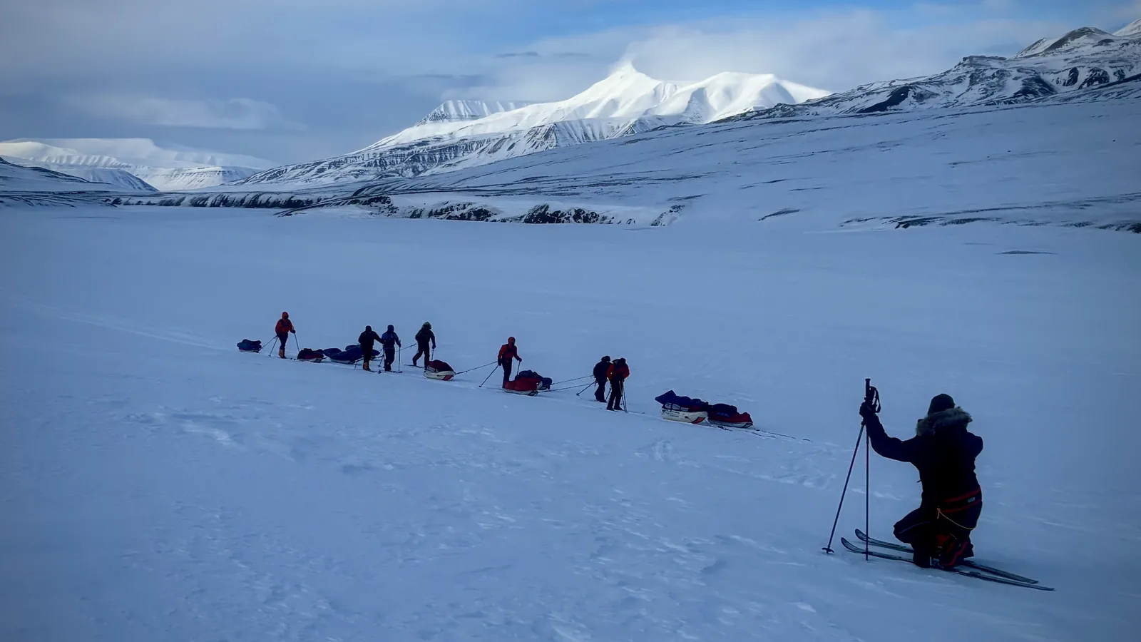 The group crossing the flat with the mountains behind