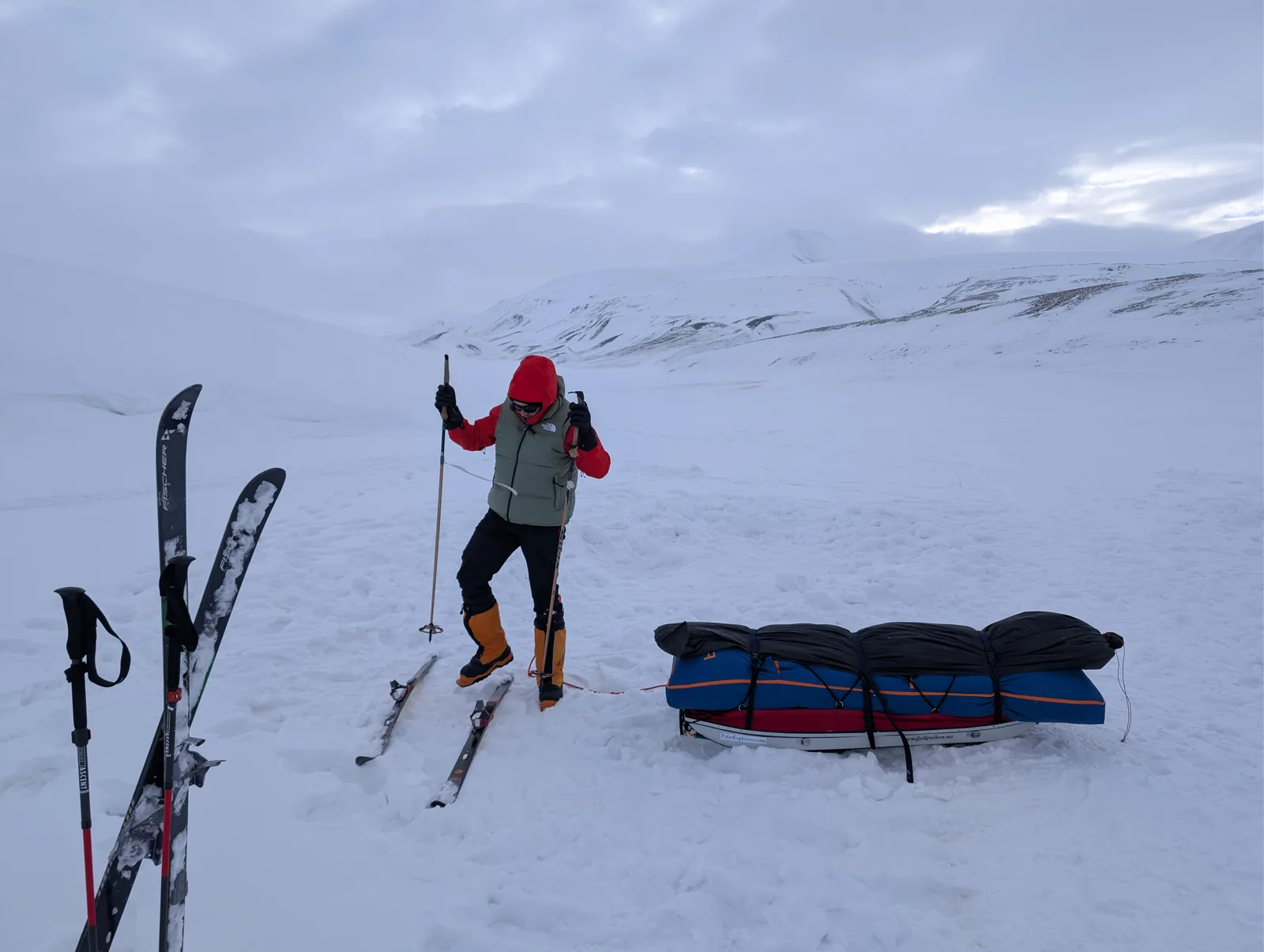 A loaded pulk with skis planted beside it