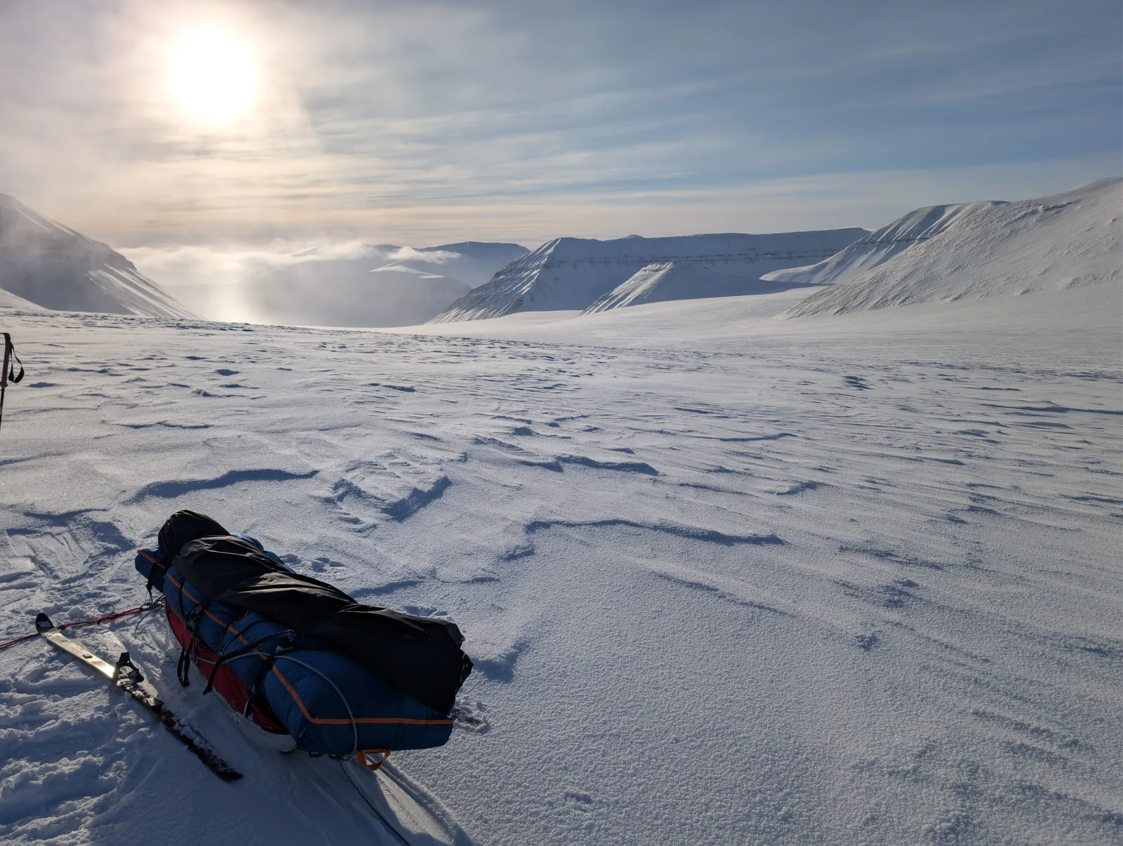 A pulk resting on wind carved snow in the valley